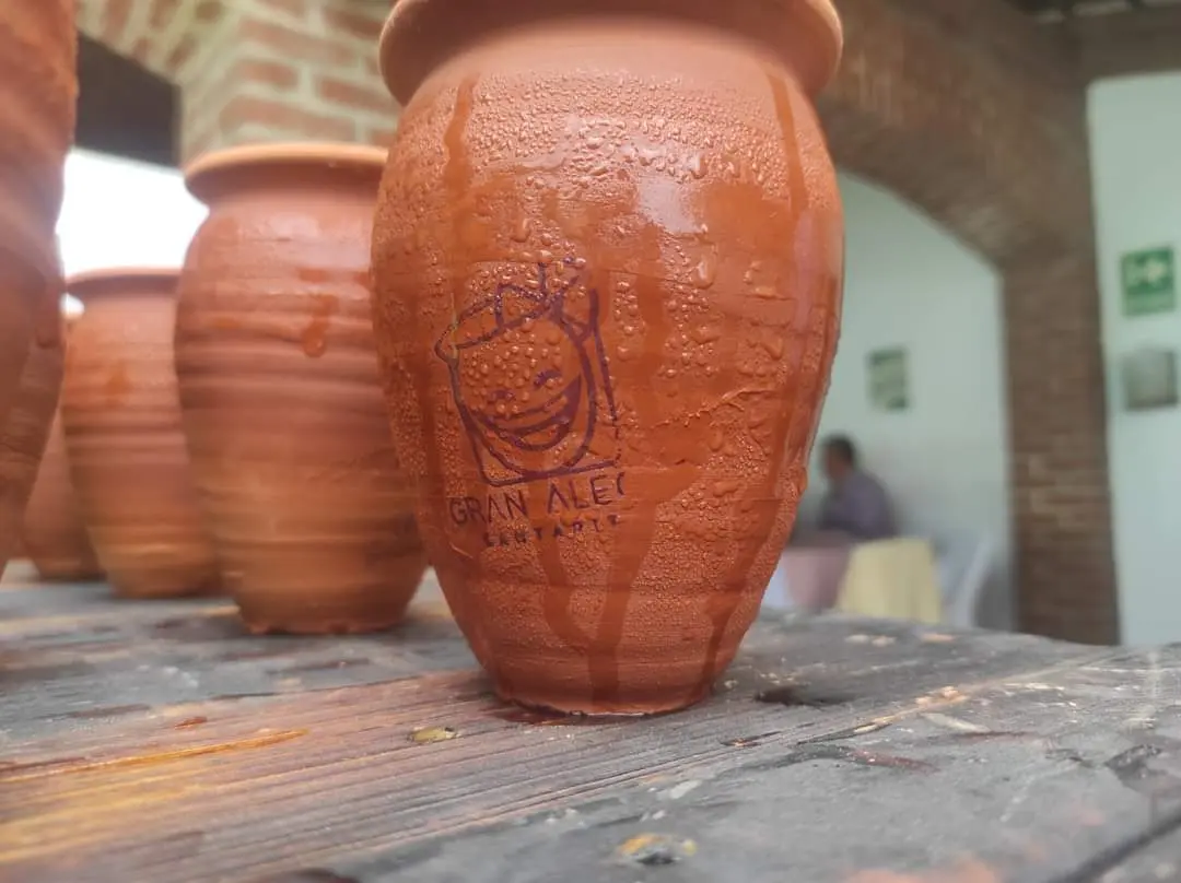 Cantarito de barro personalizado con el logotipo de Gran Alegre durante un evento real