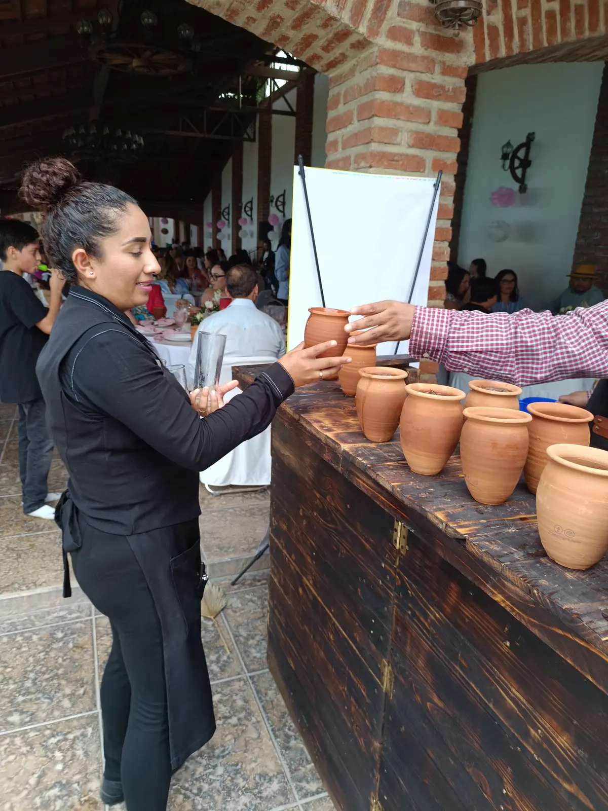 Personal de Gran Alegre entregando un cantarito a una invitada